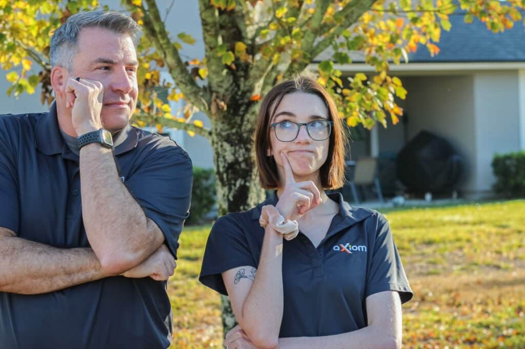 A man and woman from Axiom IT Company standing outside of their clients home