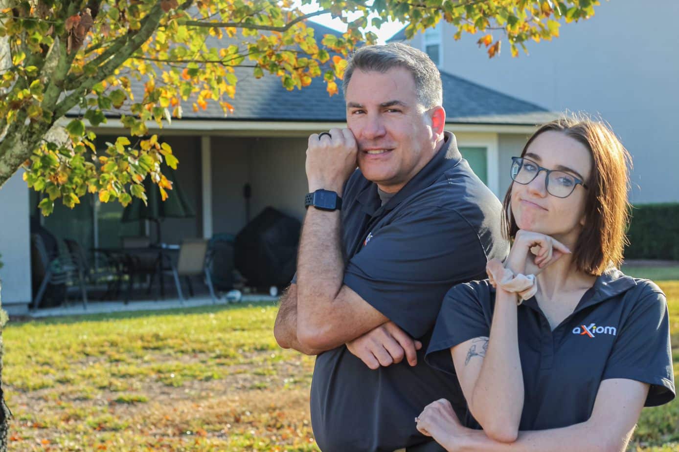 A man and woman from Axiom IT Company smiling outside of their clients home