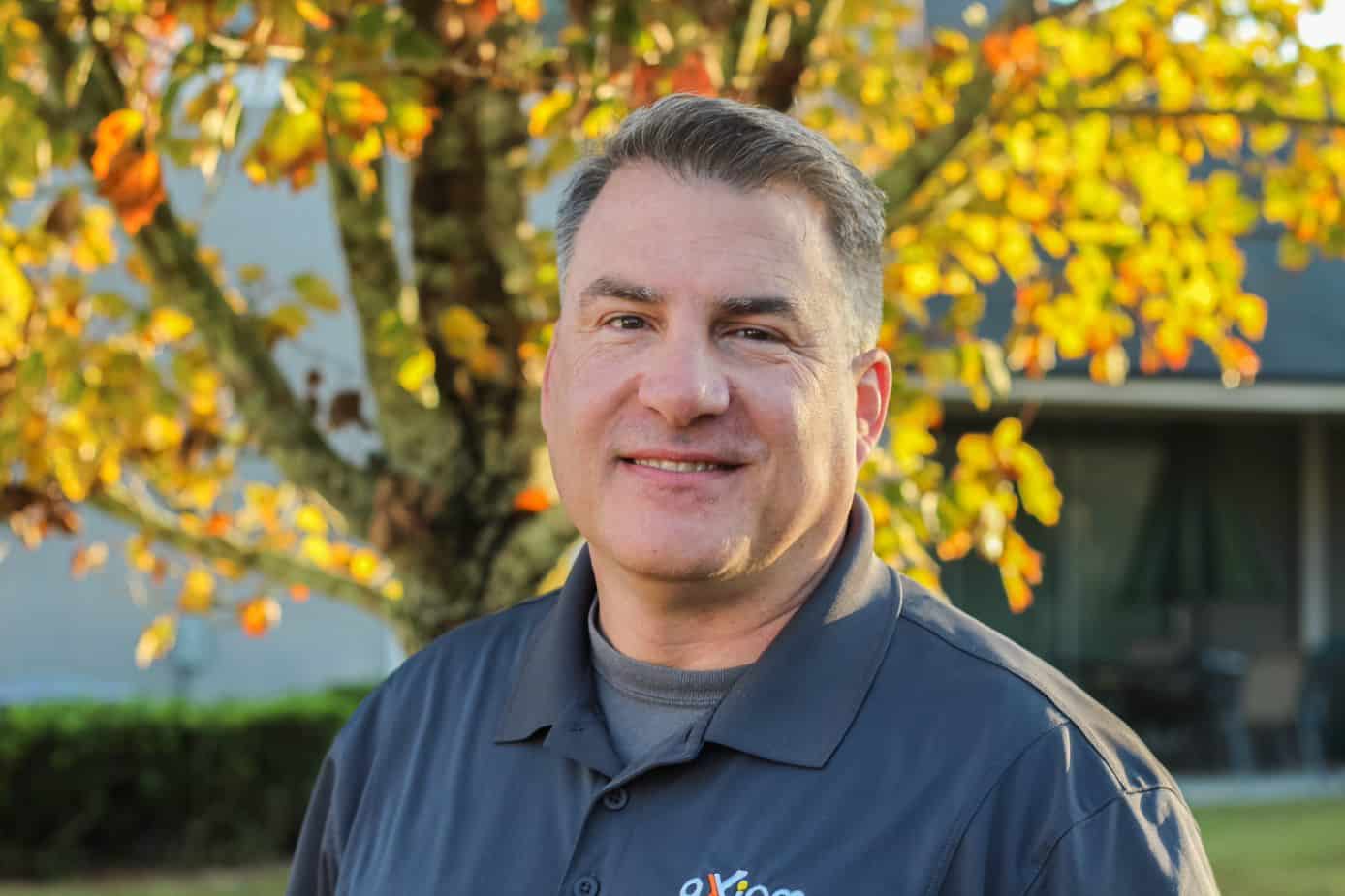 Happy looking man wearing an Axiom IT company shirt