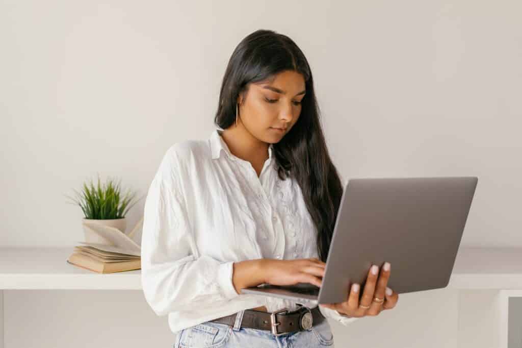 woman standing and using her laptop