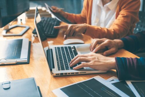 two workers on computer discussing cybersecurity solutions