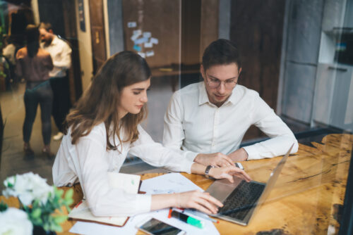 employees looking at laptop to discuss cybersecurity threats