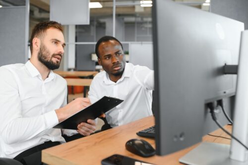 two employees discussing cybersecurity maturity model certification requirements